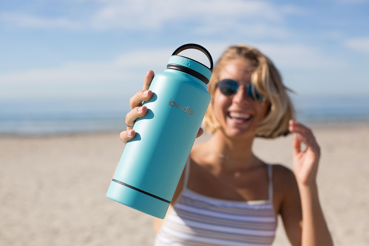 woman-holding-water-bottle-on-beach