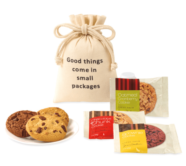 A pouch, three cookies on a plate and three cookie packages.
