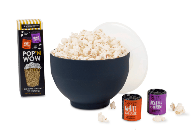 A bowl of popcorn, a box of popcorn and two small containers.